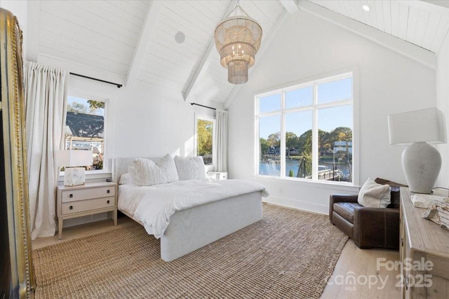 Luxurious Primary retreat with vaulted ceiling with accent lighting and waterfront views. Luxurious Primary retreat with vaulted ceiling with accent lighting and waterfront views.