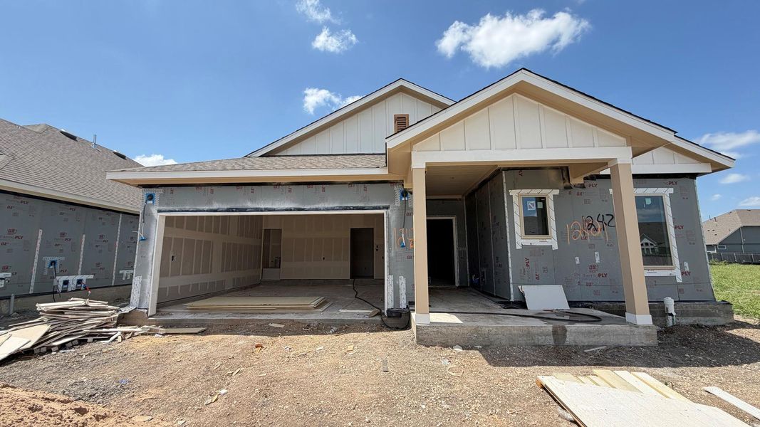 A newly framed residence awaits its finishing touches, showcasing an inviting porch entry and a spacious two-car garage. A newly framed residence awaits its finishing touches, showcasing an inviting porch entry and a spacious two-car garage.