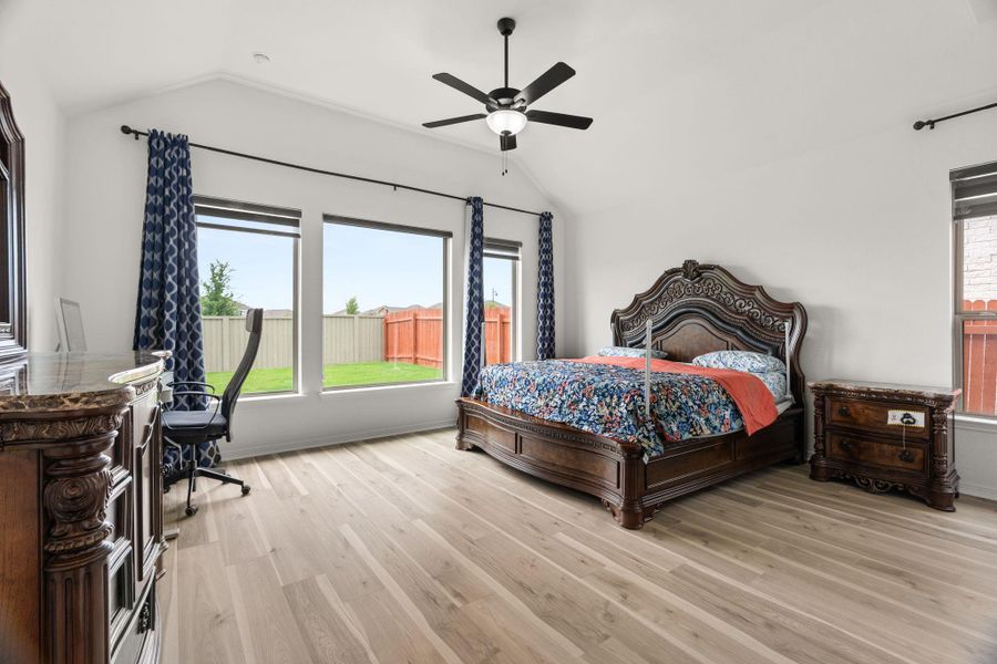 Lofty vaulted ceilings elevate this primary bedroom with natural light and durable wood flooring. Lofty vaulted ceilings elevate this primary bedroom with natural light and durable wood flooring.