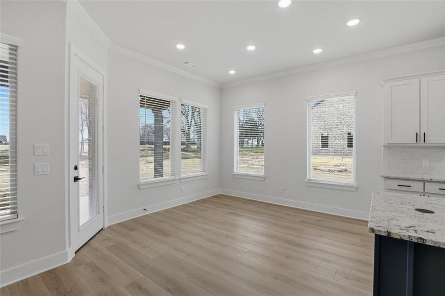 Unfurnished dining area with recessed lighting, light wood-style floors, and ornamental molding