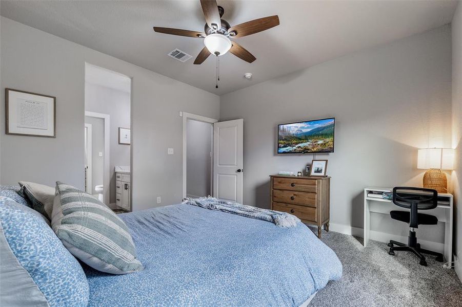 Carpeted bedroom featuring ceiling fan