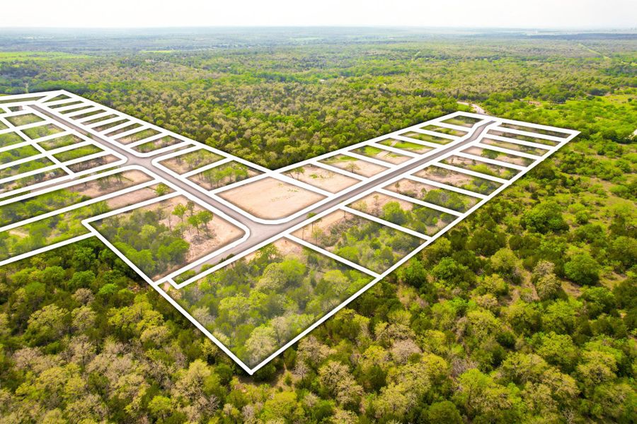 An aerial perspective reveals a thoughtfully planned residential development amidst verdant woodlands.