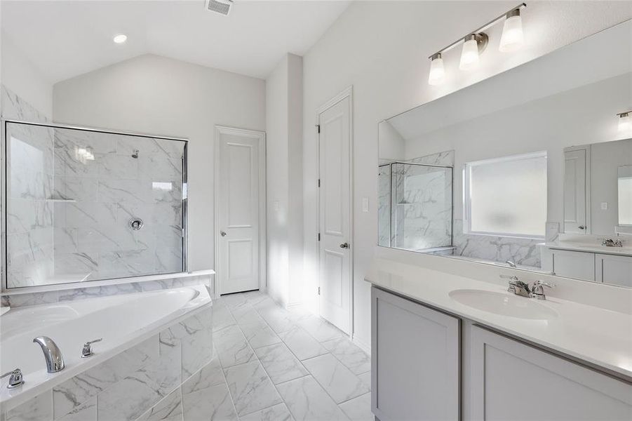 Full bath with a garden tub, light marble finish flooring, vanity, a marble finish shower, and vaulted ceiling Full bath with a garden tub, light marble finish flooring, vanity, a marble finish shower, and vaulted ceiling