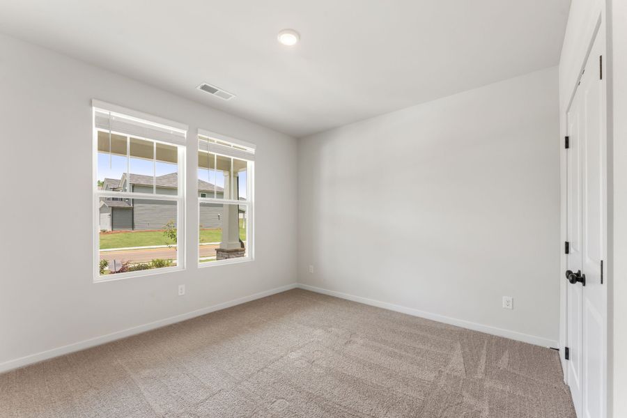 A room with a window and a carpet.