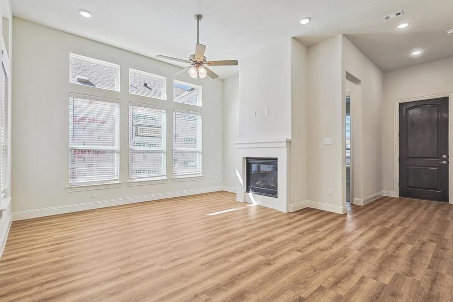 Unfurnished living room with ceiling fan and light wood-type flooring