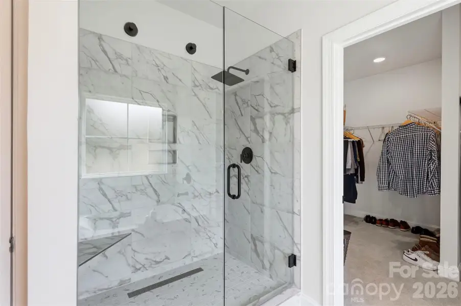 Luxurious walk-in shower with elegant tilework, and frameless glass.