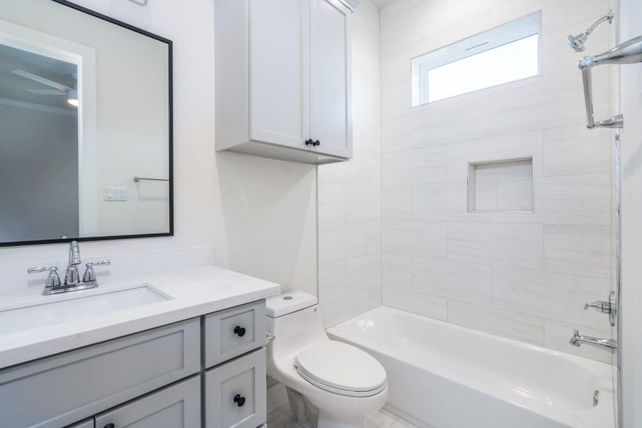 This en-suite bathroom features a shower/tub combo and storage space. This en-suite bathroom features a shower/tub combo and storage space.