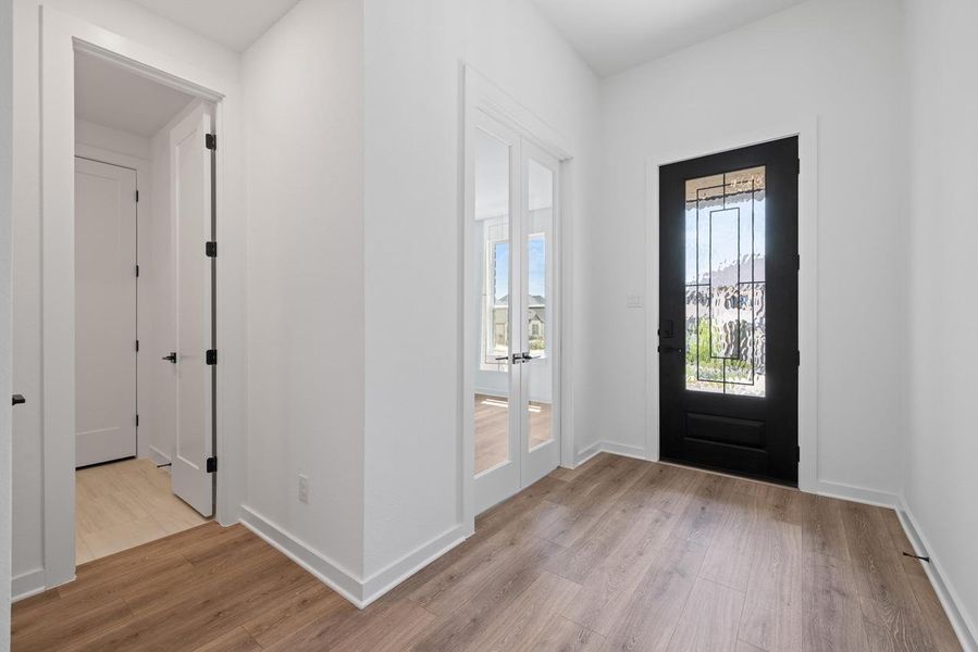 Entryway featuring light wood-type flooring and baseboards Entryway featuring light wood-type flooring and baseboards