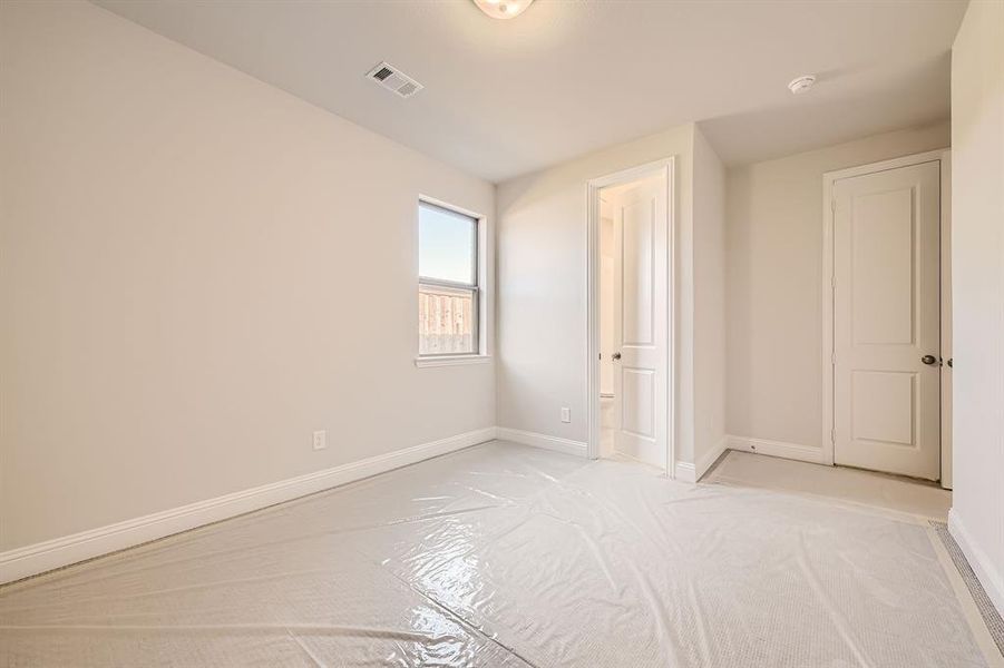 Unfurnished bedroom with light colored carpet