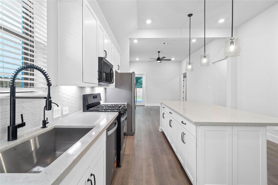 The chef's kitchen boasts timeless shaker-style cabinetry in an upscale bright white tone, beautifully accented by modern black hardware and a cohesive tile backsplash. The chef's kitchen boasts timeless shaker-style cabinetry in an upscale bright white tone, beautifully accented by modern black hardware and a cohesive tile backsplash.