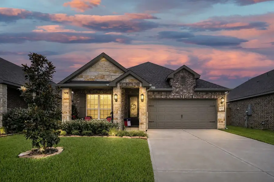 Stunning twilight curb appeal highlights the home's elegant brick-and-stone exterior, inviting covered porch, professional landscaping, and warm architectural lighting, creating a welcoming first impression day or night. Stunning twilight curb appeal highlights the home's elegant brick-and-stone exterior, inviting covered porch, professional landscaping, and warm architectural lighting, creating a welcoming first impression day or night.