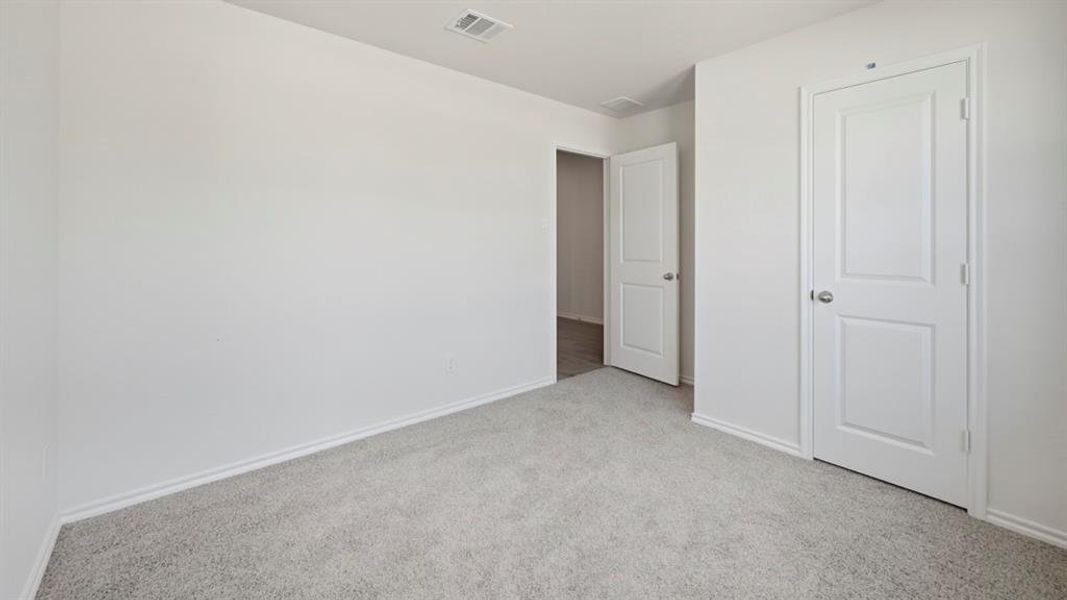 Unfurnished bedroom with carpet flooring and baseboards Unfurnished bedroom with carpet flooring and baseboards