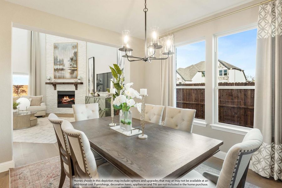 Dining room with dark wood table, upholstered chairs, chandelier, and view into living room with fireplace