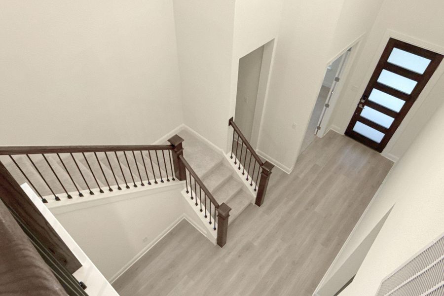 Staircase featuring wood finished floors and a high ceiling