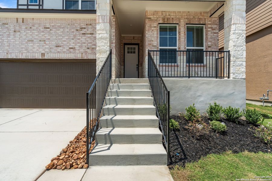 Front exterior of a new home in Hunters Ranch, San Antonio, TX, highlighting curb appeal (Image 1).