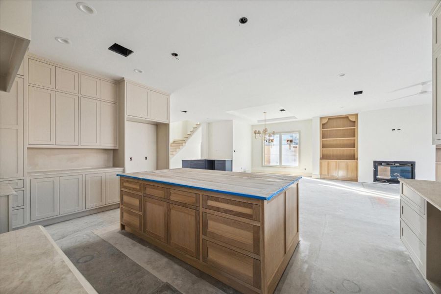 KITCHEN - Extensive cabinetry lines the kitchen with storage designed to handle both everyday use and larger gatherings, while the oversized island adds additional drawers and prep space at the center. The layout balances scale and efficiency, allowing multiple work zones without crowding the main living areas.  -- Construction as of 1/5/26