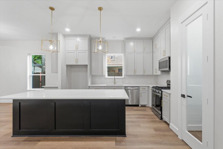 Filled with natural light, the kitchen boasts an open, spacious layout complete with a walk-in pantry and an oversized island. Filled with natural light, the kitchen boasts an open, spacious layout complete with a walk-in pantry and an oversized island.