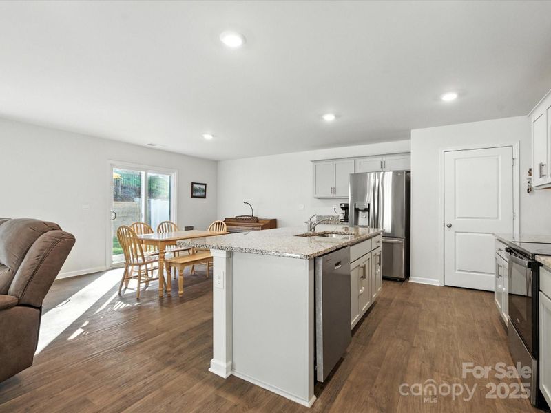 Impressive kitchen island serves as the heart of the home with granite countertops and storage below. Open sight lines to living areas create perfect space for entertaining and family interaction.
