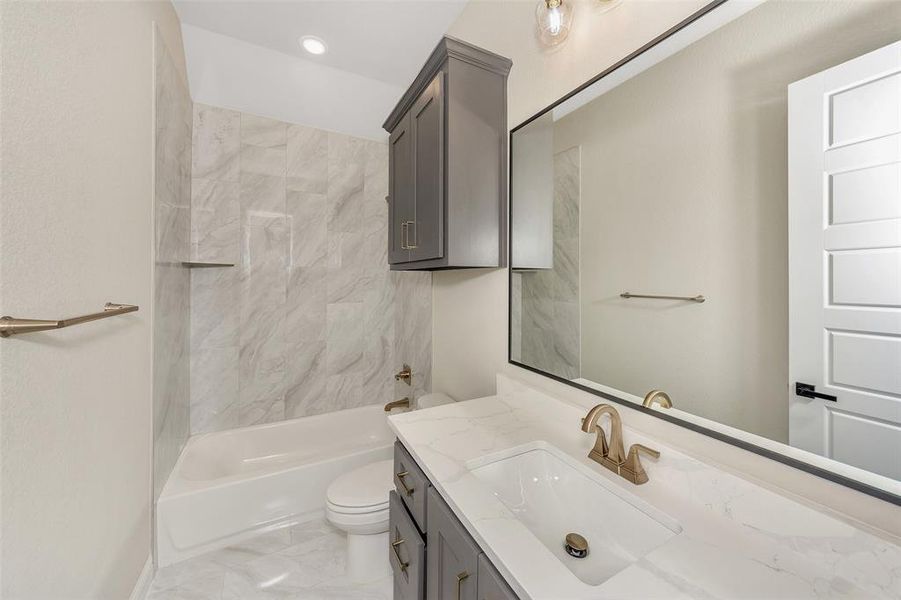 Full bathroom featuring tiled shower / bath combo, toilet, and vanity