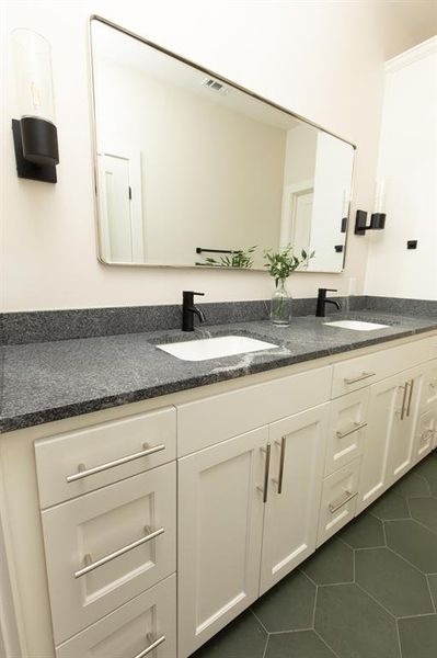 Bathroom with dark tile patterned flooring and double vanity