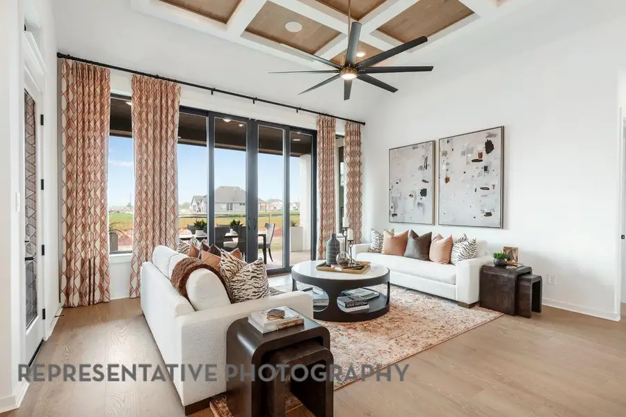 Living area with beam ceiling, a ceiling fan, baseboards, wood finished floors, and coffered ceiling