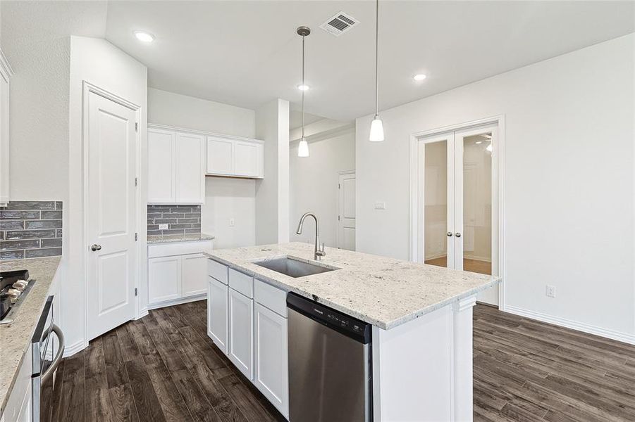 Kitchen with dishwasher, dark wood-type flooring, sink, and white cabinets