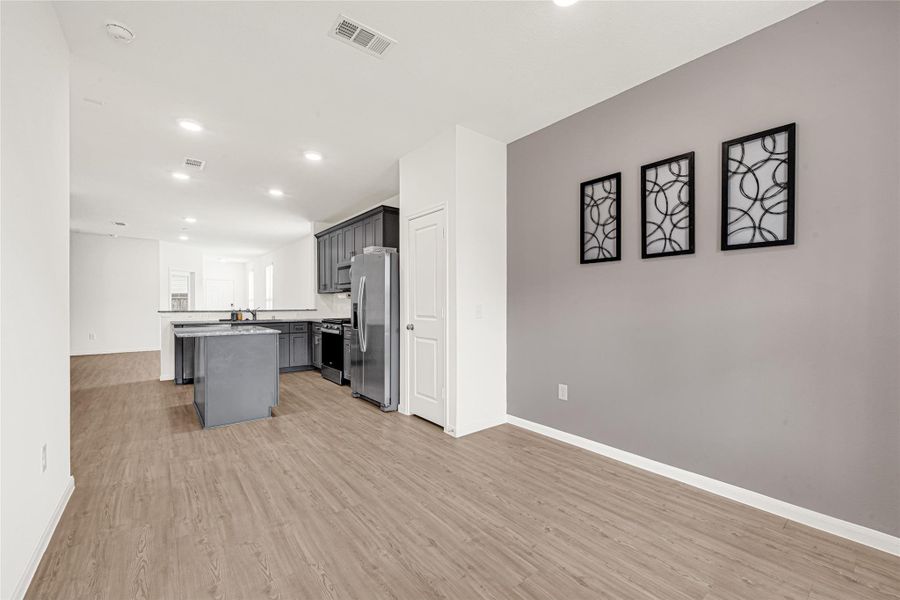 Wide view of an open-concept room featuring a striking dark grey accent wall and bright layout.
