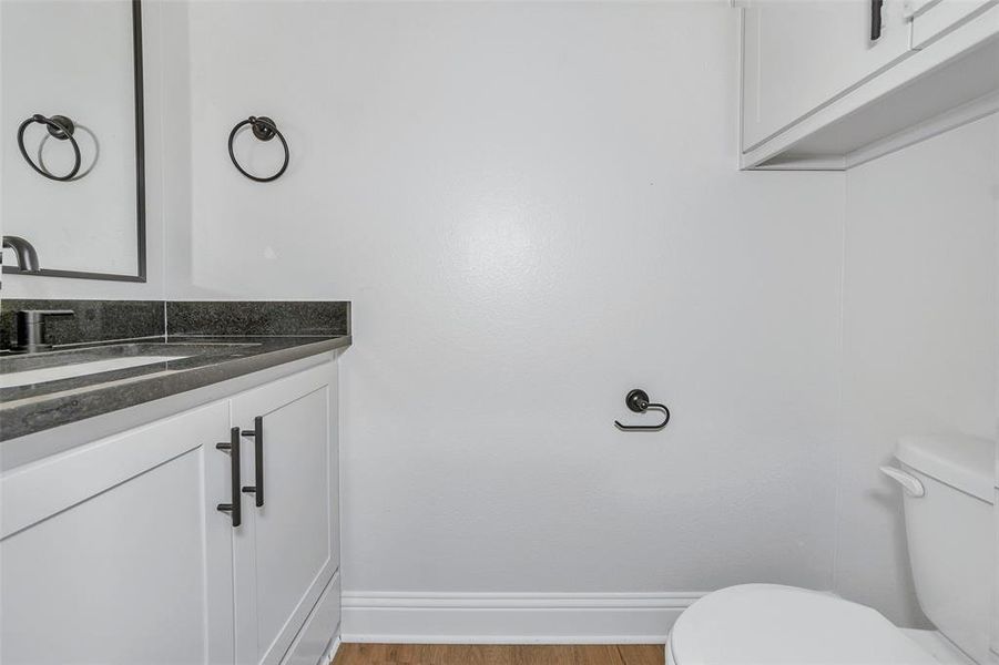 Bathroom with vanity, toilet, and hardwood / wood-style floors