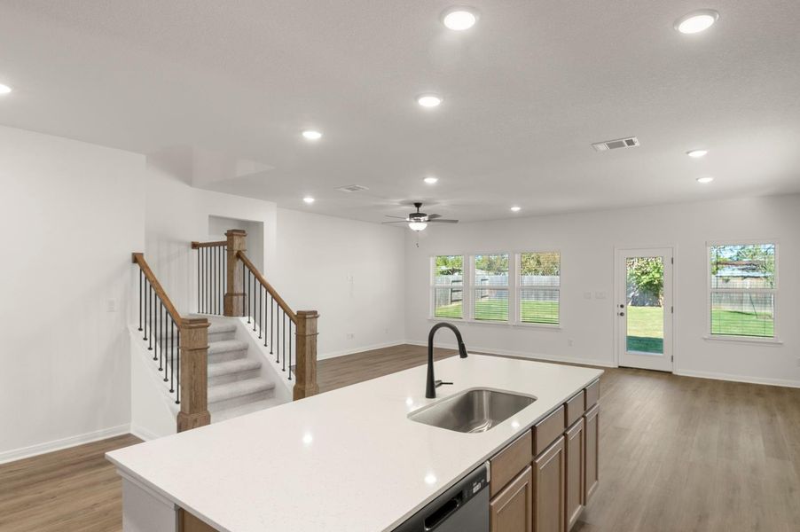 Kitchen featuring recessed lighting, open floor plan, dark wood-type flooring, an island with sink, and dishwasher Kitchen featuring recessed lighting, open floor plan, dark wood-type flooring, an island with sink, and dishwasher