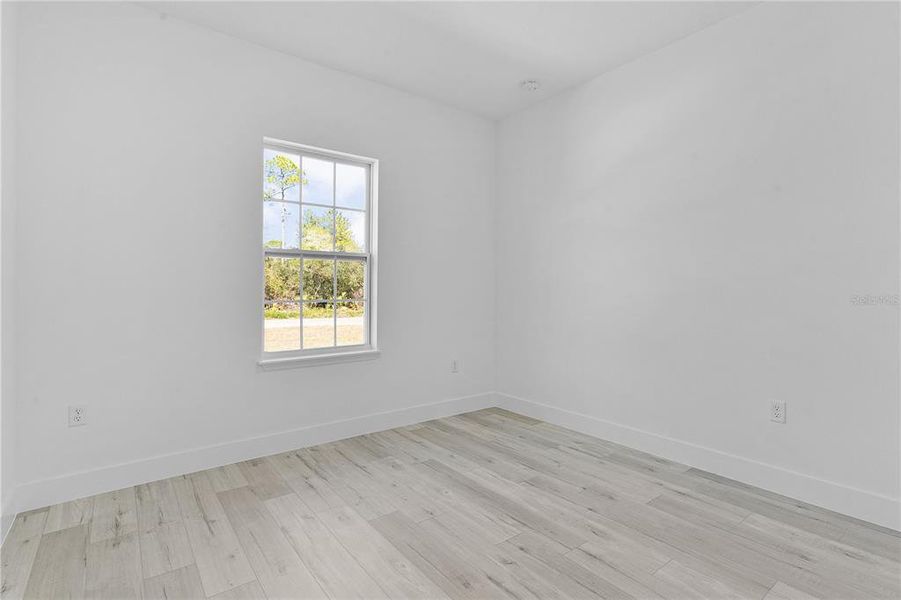 Bedroom 3, with a window looking out the front of the home