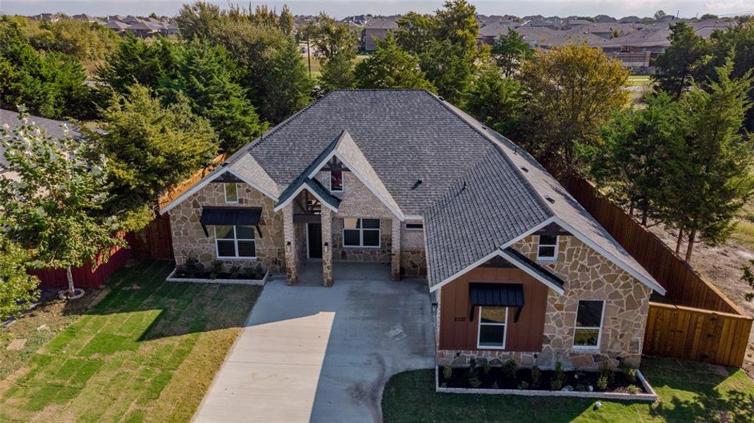 View of front of home with stone siding, board and batten siding, and concrete driveway