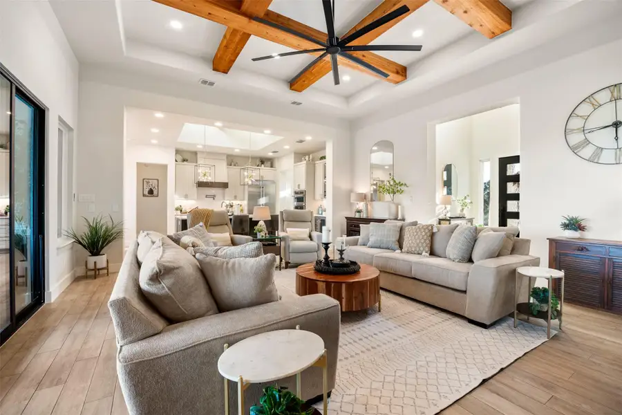 Living room with ceiling fan, coffered ceiling, beam ceiling, and a towering ceiling Living room with ceiling fan, coffered ceiling, beam ceiling, and a towering ceiling