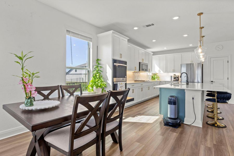 Kitchen with white cabinets, a breakfast bar, and dark wood-type flooring