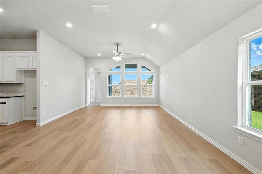 Unfurnished living room featuring ceiling fan, light wood-type flooring, recessed lighting, and vaulted ceiling Unfurnished living room featuring ceiling fan, light wood-type flooring, recessed lighting, and vaulted ceiling