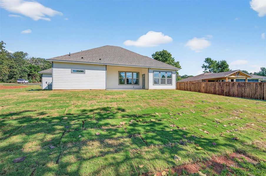Rear view of house with a patio and a shingled roof