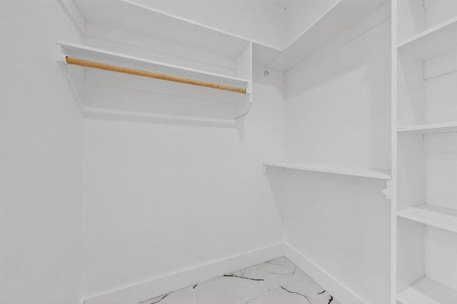 Spacious closet with light marble finish flooring