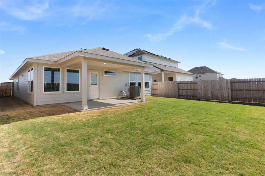 Rear view of house featuring a fenced backyard and a patio