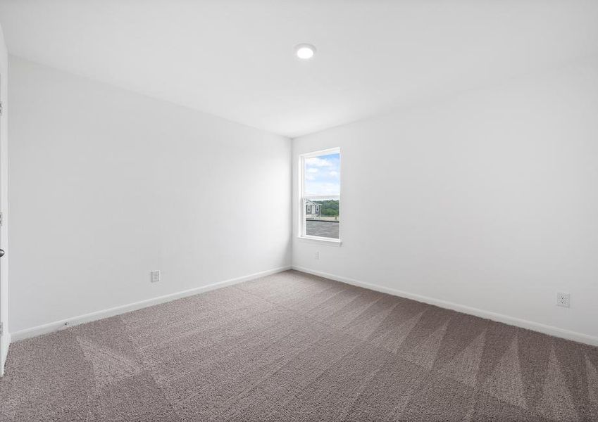 Secondary bedroom with tan carpet and recessed lighting.