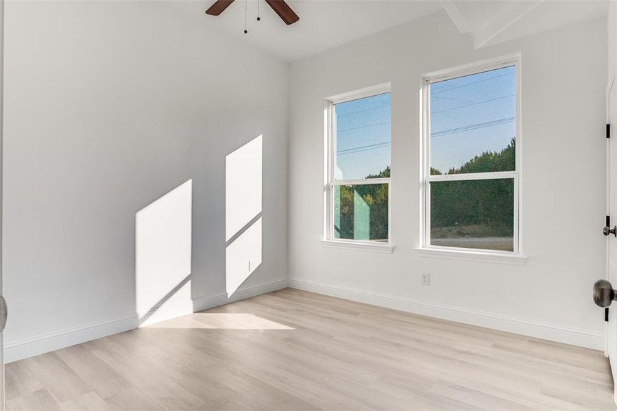 Unfurnished room with light wood finished floors and ceiling fan Unfurnished room with light wood finished floors and ceiling fan