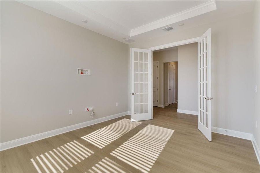 Upgraded tray ceilings and french doors add to the upscale ambiance of the home.