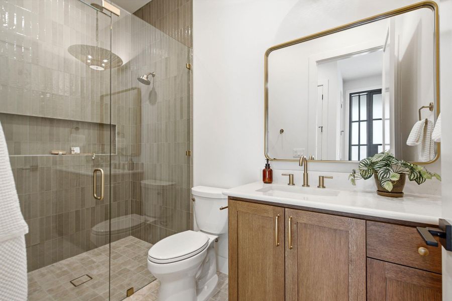 Clean lines and warm wood accents define this modern bathroom with a glass-enclosed shower.