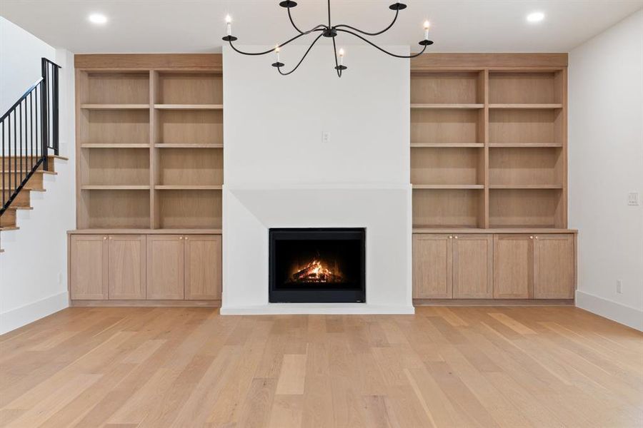 The family room exudes sophistication with custom shelves and a custom plaster fireplace that complements the kitchen’s design.