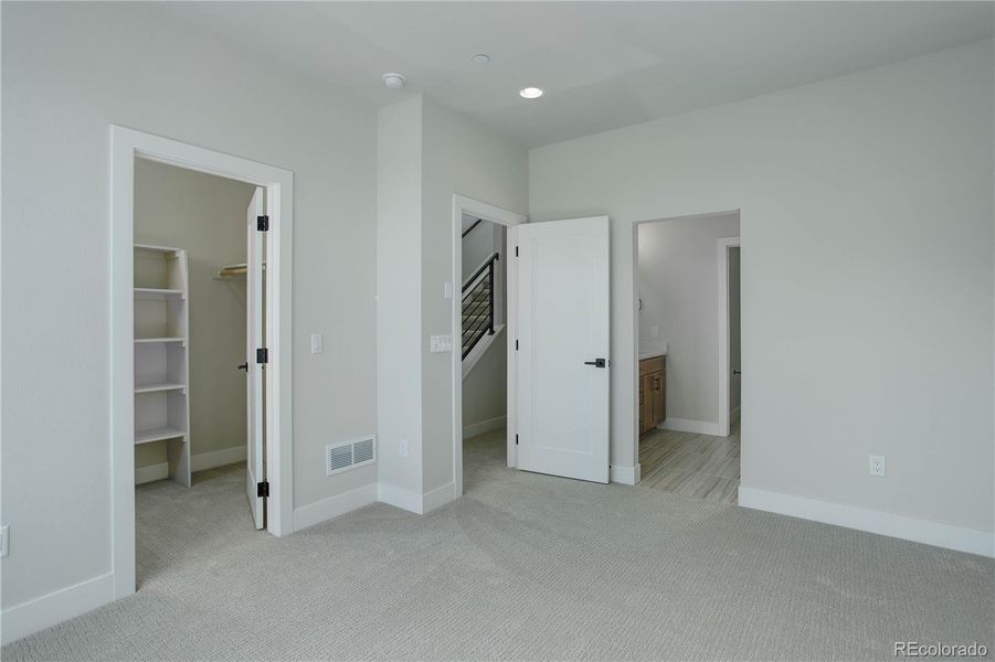 Third level hallway with metal railings and laundry/linen closet w/full size washer and dryer