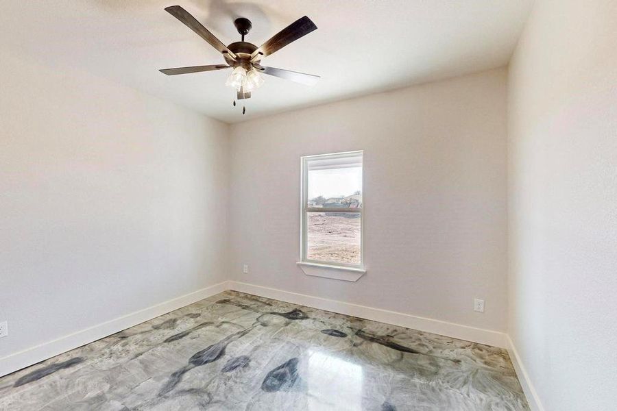 Unfurnished room with ceiling fan and baseboards