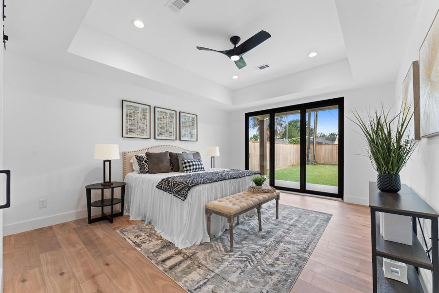 A true owner’s retreat, anchored by a tray ceiling, recessed lighting, and peaceful backyard access.