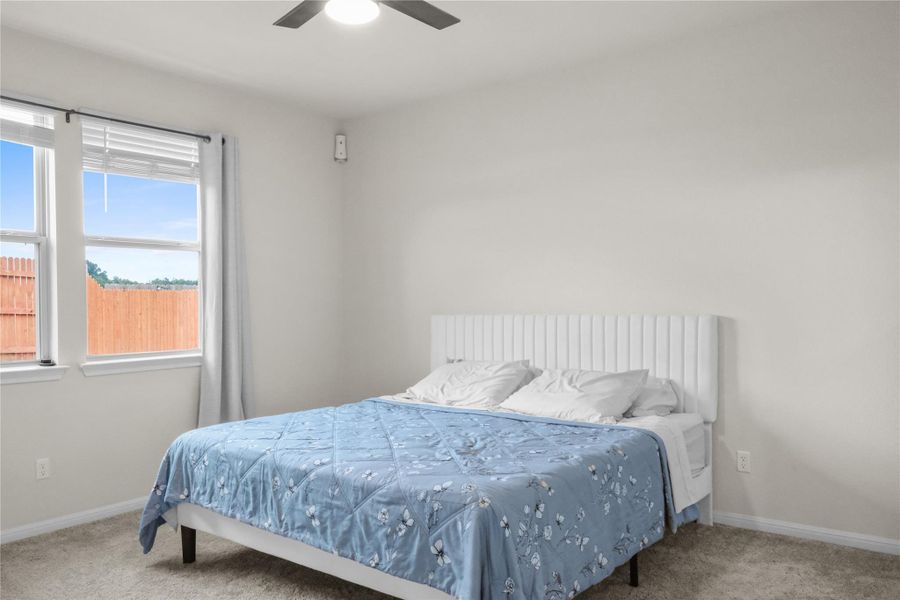 Bedroom featuring light carpet and a ceiling fan