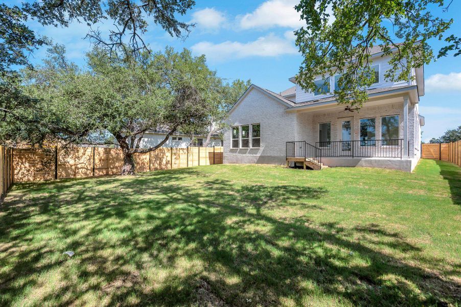 Back of house featuring a fenced backyard and brick siding
