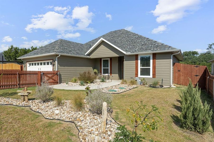 Ranch-style home featuring a gate, an attached garage, a porch, and a shingled roof