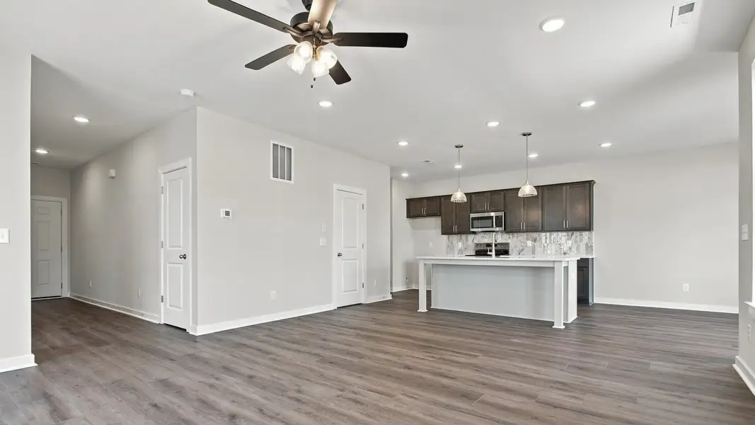 Versatile living/dining area with ceiling fan and modern light fixtures
