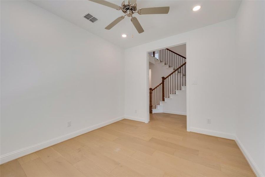 Empty room with light hardwood / wood-style floors and ceiling fan